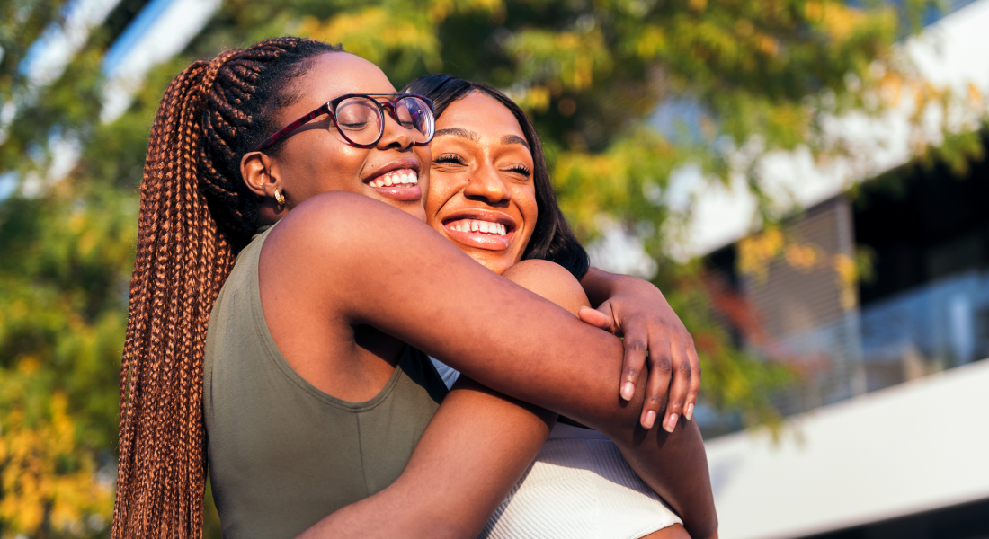 Two women hugging each other outdoors